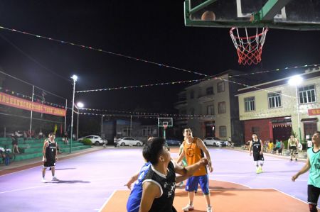 (miniature) Des villageois jouent au basket sous les éclairages publics à énergie solaire dans le village de Huyang