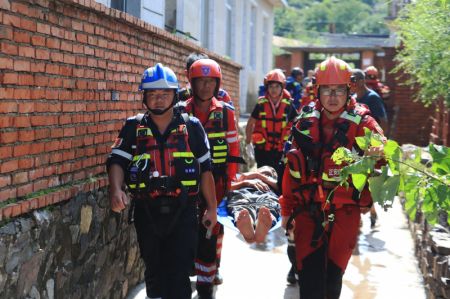 (miniature) Des membres de l'équipe de secours évacuent un résident âgé ayant besoin de soins médicaux dans le village d'Erdaohezi du bourg de Heishanke