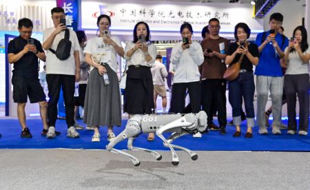 (miniature) Des visiteurs observent un chien robot lors du Salon international de l'optoélectronique de Changchun 2024 à Changchun