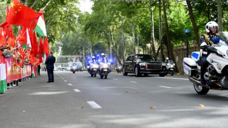 (miniature) Des expatriés chinois et des représentants d'institutions financées par la Chine agitent les drapeaux nationaux de la Chine et du Tadjikistan des deux côtés de la route