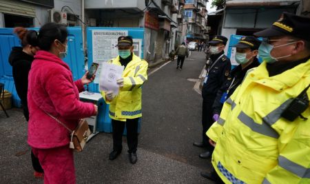(miniature) Des gens scannent leurs codes de santé à un point de contrôle de l'épidémie dans un quartier de Wuhan
