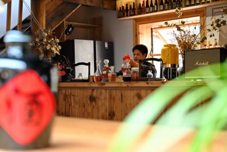 (miniature) Une employ&eacute;e d'un magasin de vin jaune pr&eacute;pare du vin jaune local pour les touristes dans le village de Beiqian du bourg de Daixi