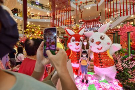 (miniature) Des personnes prises en photo avec des membres du personnel déguisés en lapin pour accueillir le Nouvel An lunaire chinois dans un centre commercial de Kuala Lumpur