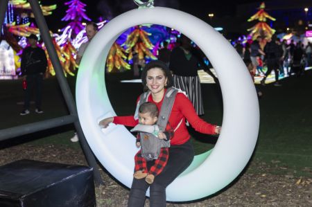 (miniature) Une mère est assise avec son bébé sur une chaise lumineuse lors du Festival des lumières Tianyu dans la banlieue de Dallas