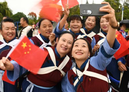 (miniature) Des gens font un selfie après une cérémonie de levée du drapeau national célébrant le 75e anniversaire de la fondation de la République populaire de Chine dans le district autonome Naxi de Yulong