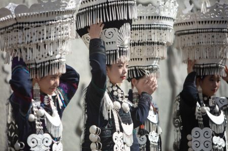 (miniature) Des habitants locaux vêtus de costumes traditionnels de l'ethnie Yi marchent dans une rue