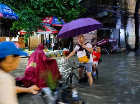 (miniature) Des gens traversent une rue inondée à Guangzhou