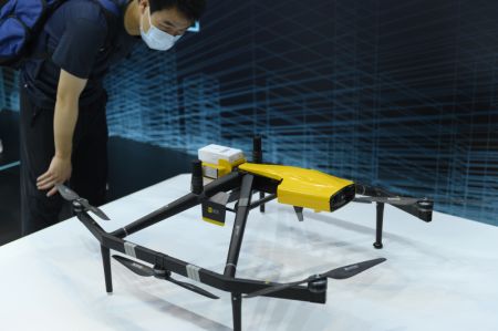 (miniature) Un visiteur regarde un drone de livraison à la Conférence mondiale sur l'intelligence artificielle 2021 à Shanghai