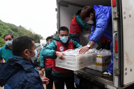 (miniature) Des membres du personnel transportent de la nourriture pour les secouristes dans le village de Molang du district de Tengxian