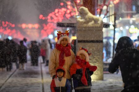 (miniature) Des touristes posent pour des photos dans la rue Qianmen sous la neige
