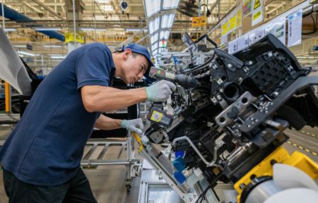 (miniature) Un ouvrier installe un airbag sur un véhicule sur une chaîne de montage de la société Dongfeng Motor Corporation