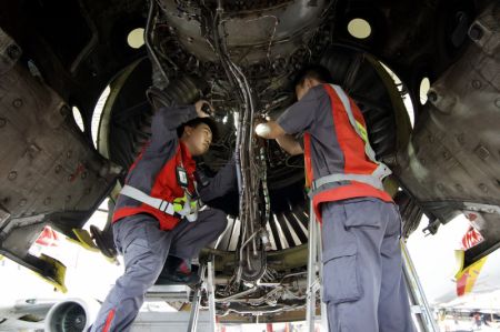 (miniature) Des techniciens de HNA Technic en plein exercice d'entretient d'un avion entrant à la base de maintenance aéronautique du Port de libre-échange de Hainan à Haikou