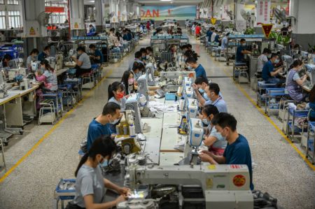(miniature) Des employ&eacute;s travaillent sur une ligne de production d'une entreprise de chaussures de sport