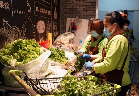 (miniature) Des employés emballent des légumes dans un supermarché de l'arrondissement de Haidian à Beijing