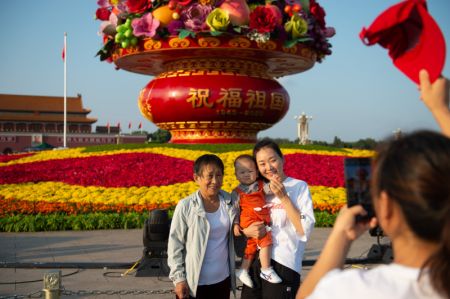 (miniature) Des touristes posent pour une photo devant un panier de fleurs sur la place Tian'anmen &agrave; Beijing