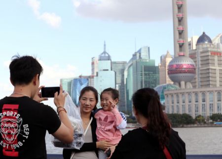 (miniature) Des touristes posent pour une photo sur le Bund à Shanghai