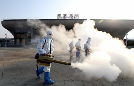 (miniature) Des membres du personnel désinfectent la place ouest de la gare de Shijiazhuang