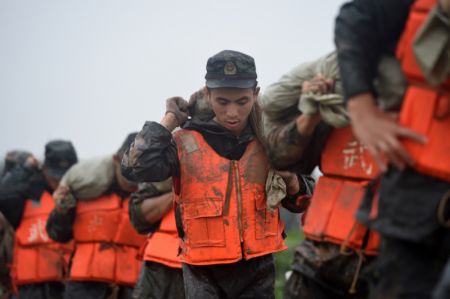 (miniature) Des policiers arm&eacute;s portent des sacs de sable sur la digue de la rivi&egrave;re Shiba