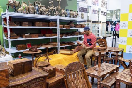 (miniature) Un exposant &eacute;tranger dispose des produits lors de l'Exposition d'art et de design d'Asie du Nord-Est