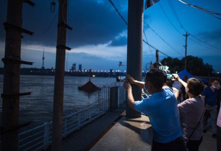 (miniature) Des gens prennent des photos du fleuve Yangtsé dans lequel un pavillon est submergé par la montée des eaux à Wuhan