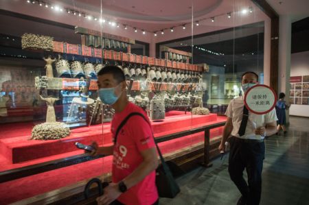 (miniature) Un employé rappelle aux visiteurs de garder une distance entre eux au musée provincial du Hubei