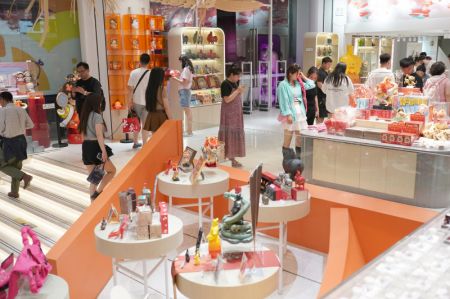 (miniature) Des touristes sélectionnent des produits culturels et de création dans une boutique du centre commercial Great Tang All Day Mall à Xi'an