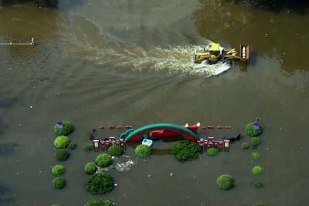 (miniature) Une pelleteuse transporte du matériel dans la ville inondée de Weihui