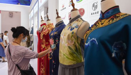 (miniature) Des visiteurs examinent des vêtements chinois présentés lors de la deuxième Exposition internationale des produits de consommation de Chine