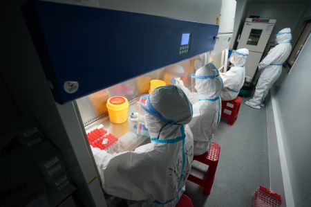 (miniature) Des membres du personnel médical travaillent dans un laboratoire temporaire pour des tests d'acide nucléique sur la place de la gare de Nanjing
