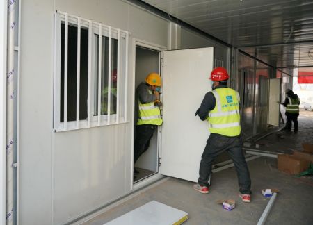 (miniature) Des ouvriers installent des portes sur le site de construction d'un centre d'isolement à Shijiazhuang