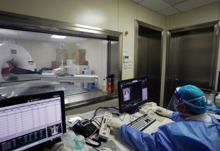 (miniature) Un membre du personnel médical effectue une tomodensitométrie (CT) sur un patient à la clinique spécialisée dans le traitement de la fièvre d'un établissement de santé communautaire à Shanghai