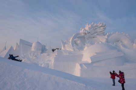(miniature) Des visiteurs prennent des photos lors de la 33e Exposition internationale d'art de sculpture sur neige de Harbin