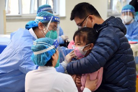 (miniature) Une enfant reçoit une dose de vaccin contre la COVID-19 dans un site de vaccination dans l'arrondissement de Haidian à Beijing
