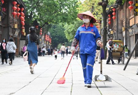 (miniature) Une travailleuse d'assainissement nettoie une rue de Fuzhou