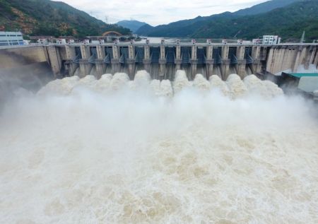 (miniature) La centrale hydroélectrique de Shuikou ouvre ses écluses pour lâcher de l'eau après des jours de pluies sur le cours supérieur de la rivière Minjiang dans le district de Minqing