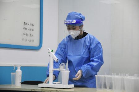 (miniature) Un professionnel médical prépare des doses de vaccin inhalable contre la COVID-19 sur un site de vaccination