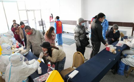 (miniature) Des professionnels de la sant&eacute; pr&eacute;l&egrave;vent des &eacute;chantillons sur &eacute;couvillon aux habitants dans un site de tests d'acide nucl&eacute;ique de l'arrondissement de Xiangfang