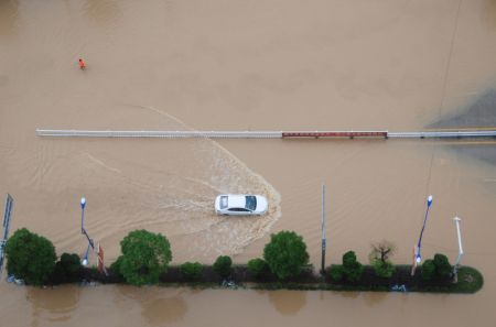 (miniature) Un véhicule traverse une route inondée à Hezhou