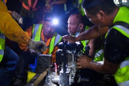 (miniature) Des constructeurs ferroviaires travaillent toute la nuit pour effectuer des am&eacute;liorations ferroviaires