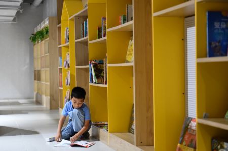 (miniature) Un enfant lit dans une librairie à Changsha