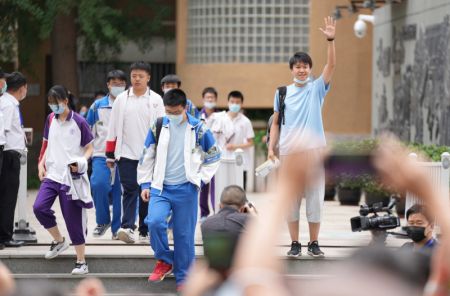 (miniature) Un candidat fait un signe de la main en quittant un site d'examen à l'issue de la première épreuve dans un lycée de Beijing