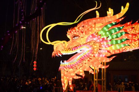 (miniature) Des gens contemplent une lanterne géante en forme de dragon lors d'une foire dans l'arrondissement de Xicheng à Beijing