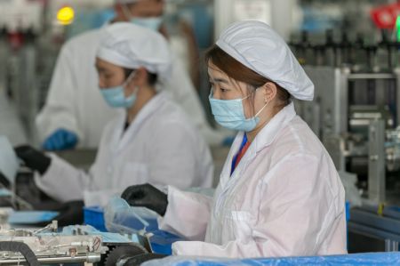 (miniature) Des travailleurs produisent des masques de protection dans une usine de masques de Threegun Group