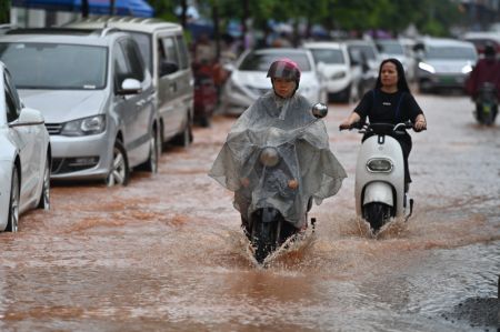 (miniature) Des habitants en scooter dans une rue inondée de Nanning