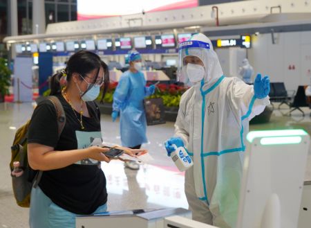 (miniature) Une passagère s'apprête à subir un contrôle de sécurité à l'aéroport international Meilan de Haikou