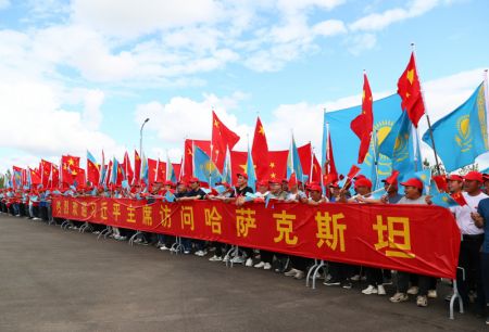 (miniature) Des représentants d'entreprises locales accueillent chaleureusement le président chinois Xi Jinping sur le bord de la route lorsque le cortège de M