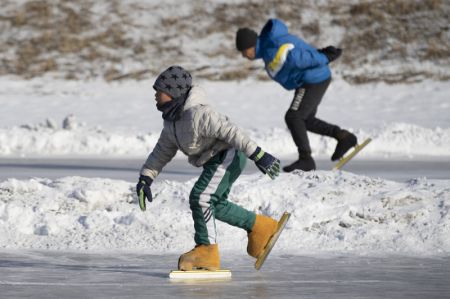 (miniature) Des gens patinent sur une patinoire à Qitaihe