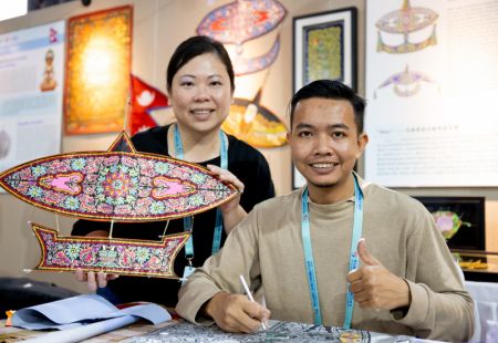 (miniature) Un artiste malaisien et sa partenaire présentent un cerf-volant
