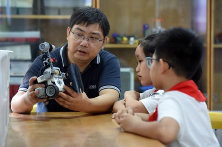 (miniature) Yang Sen donne des instructions à ses élèves au club de robotique de l'Ecole primaire Heping