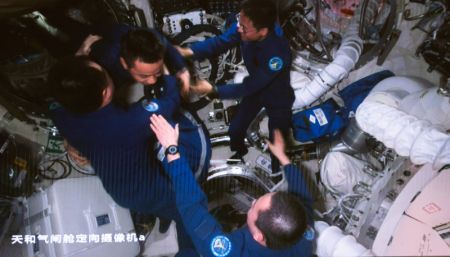 (miniature) Image captur&eacute;e au Centre de contr&ocirc;le des vols a&eacute;rospatiaux de Beijing montrant les astronautes de la mission Shenzhou-16 en train d'accueillir l'&eacute;quipage de Shenzhou-17 dans la station spatiale chinoise